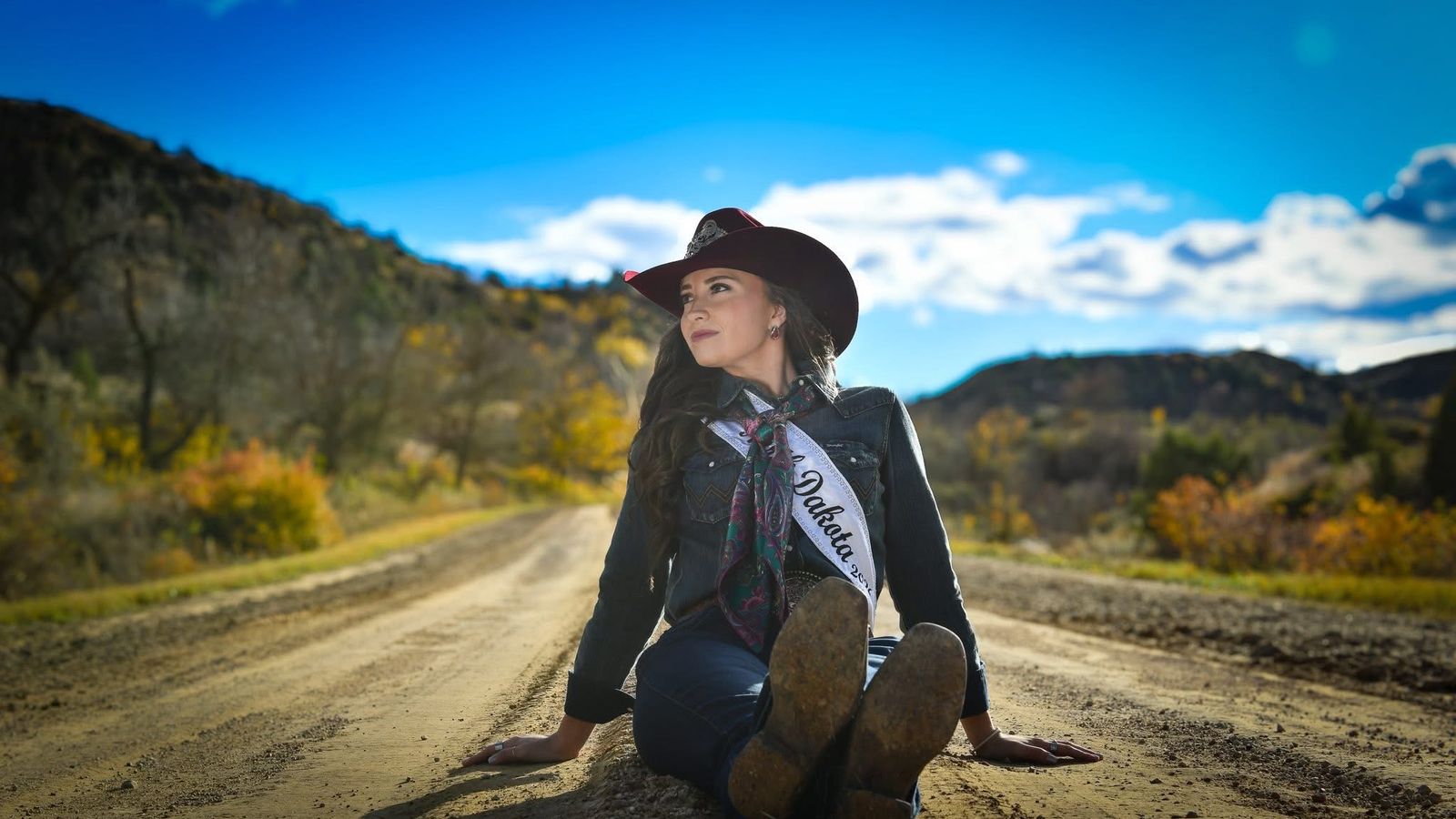 Jaylynn Hicks sits on an old stretch of road at the badlands near Killdeer, North Dakota, on Thursday, Oct. 16, 2025. (Photo credit: Chuck Miner)
