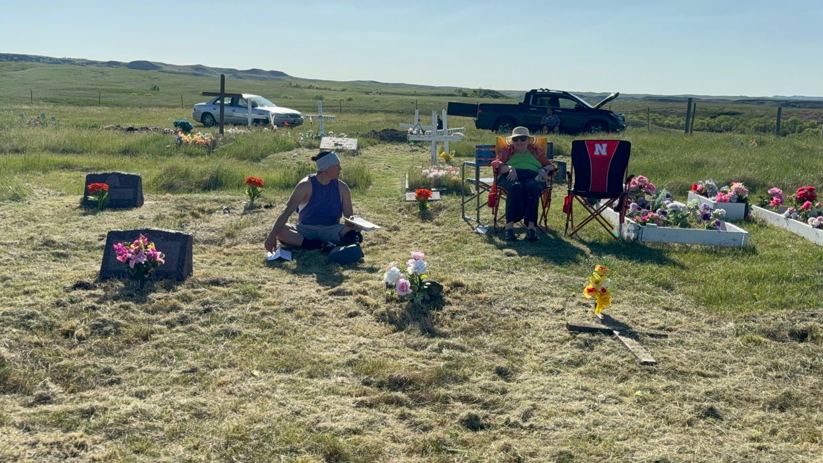 Mary Lee Johns sits with her nephew Luke Fox in the Green Grass Cemetery in Green Grass, South Dakota, Monday, May 25, 2026. She recounted the stories of the Fights the Thunder and Poor Buffalo relatives who were present at the Battle of the Little Bighorn on June 25, 1876, many of whom are now buried in the cemetery.