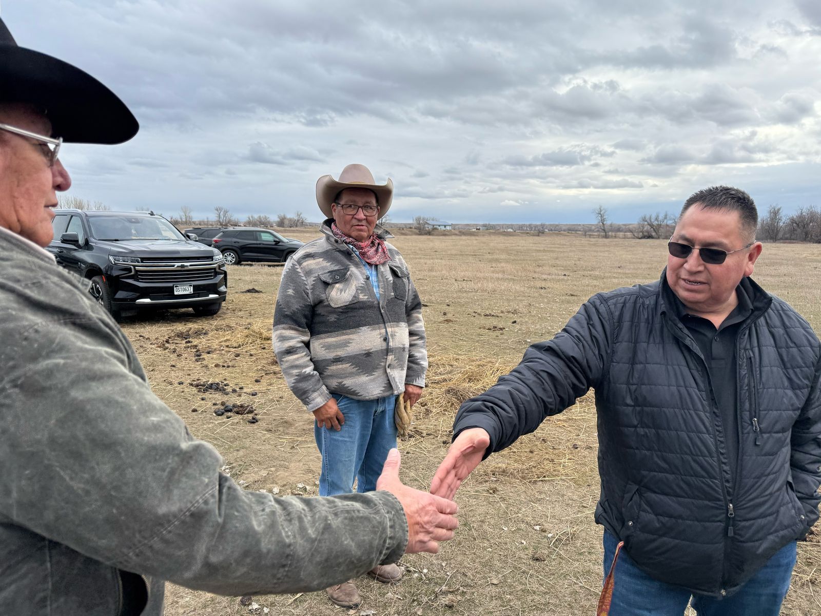 President Frank Star Comes Out, Oglala Sioux Tribe, shakes hands with Jim Real Bird with Curtis Real Bird looking on March 5, 2026.  The Real Birds, Crow citizens, offered their land for the 150th commemoration of the Battle of the Greasy Grass commemoration.