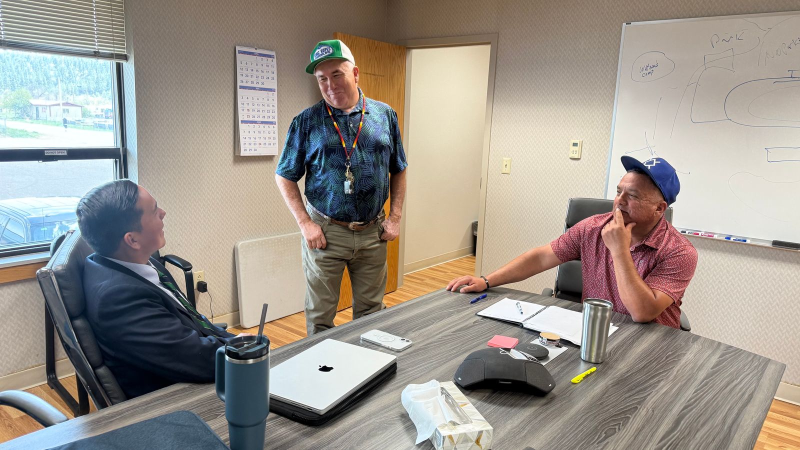 Lorenzo Roan Bear, legal advocate for the Northern Cheyenne Tribe, left, talks to Councilman Robert Simpson and President Gene Small in a conference room in the tribe’s administration building, May 20, 2026