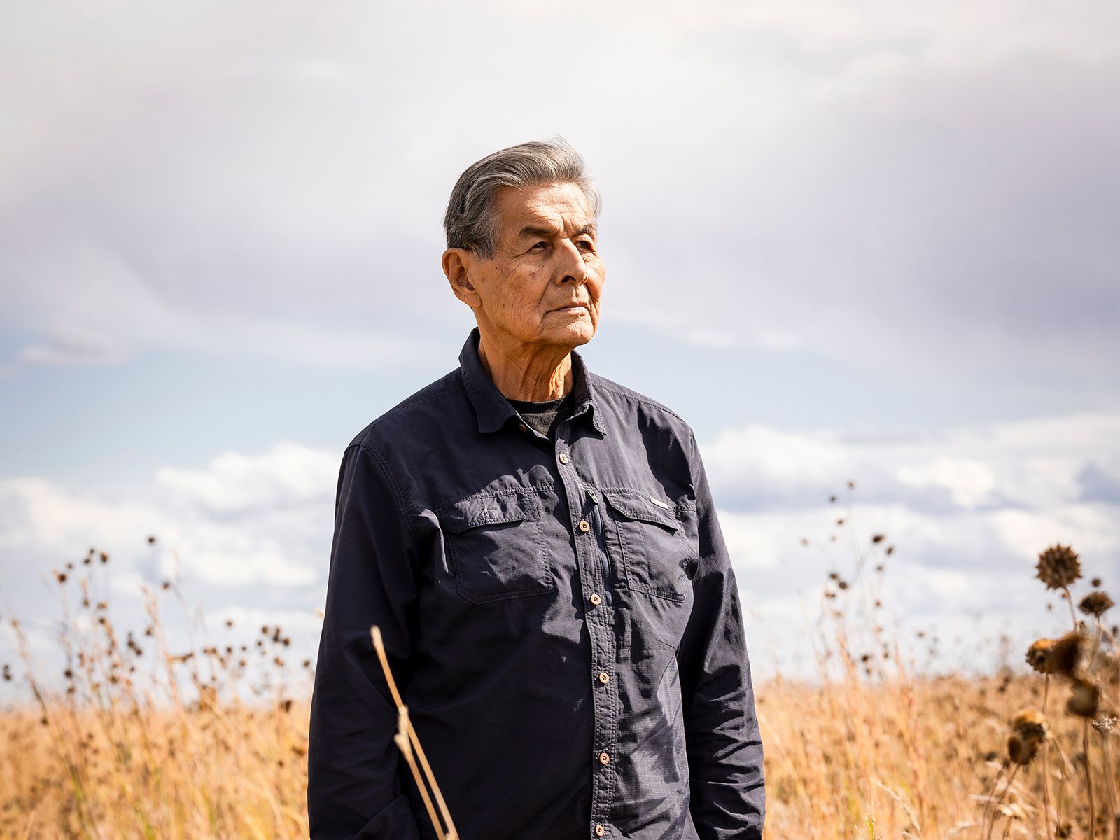 Joseph M. Marshall III, a skilled bow maker, holds a traditional style Lakota bow and arrows.