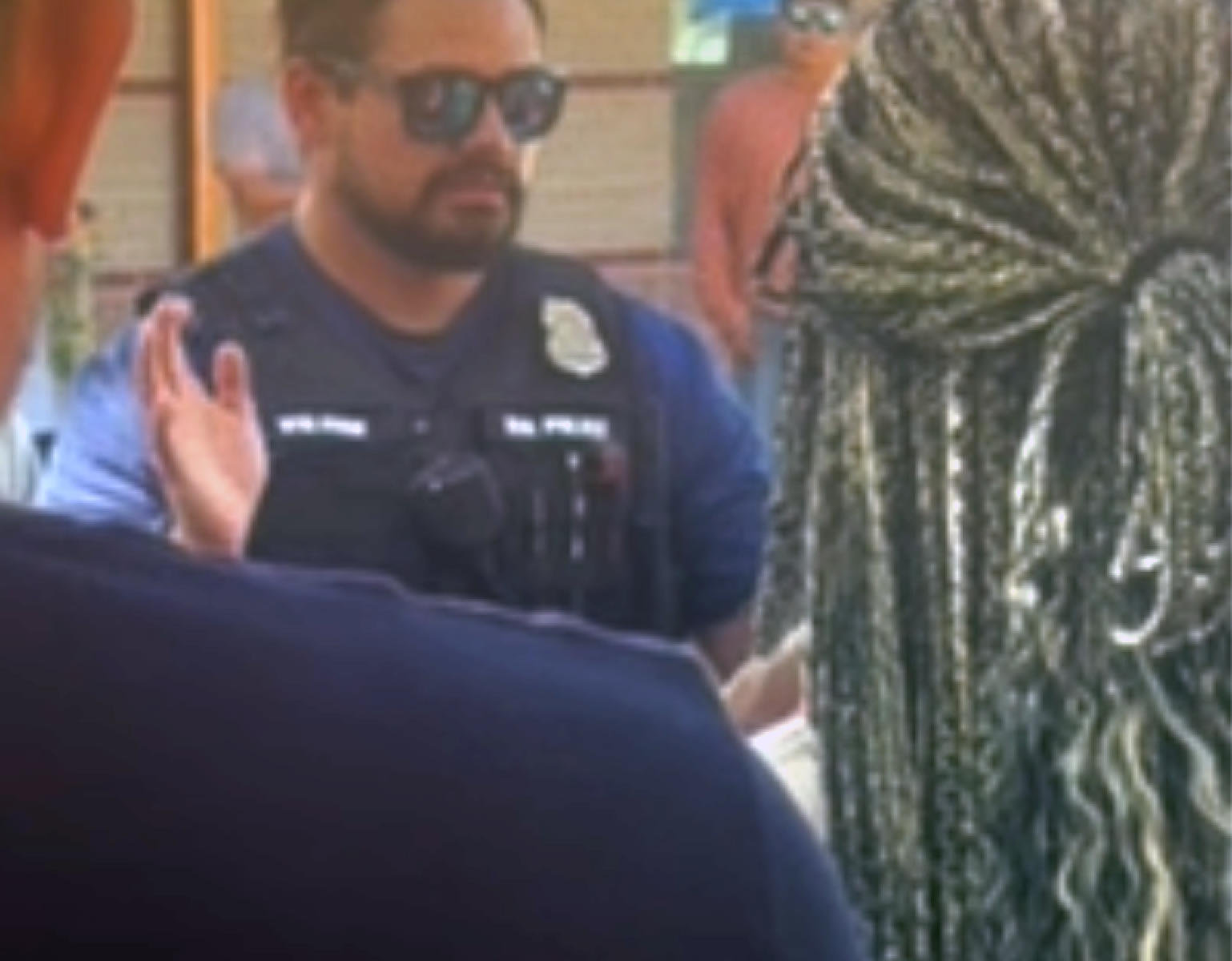 A law enforcement officer speaks to a crowd outside the Little Wolf Capitol Building in Lame Deer, Montana.