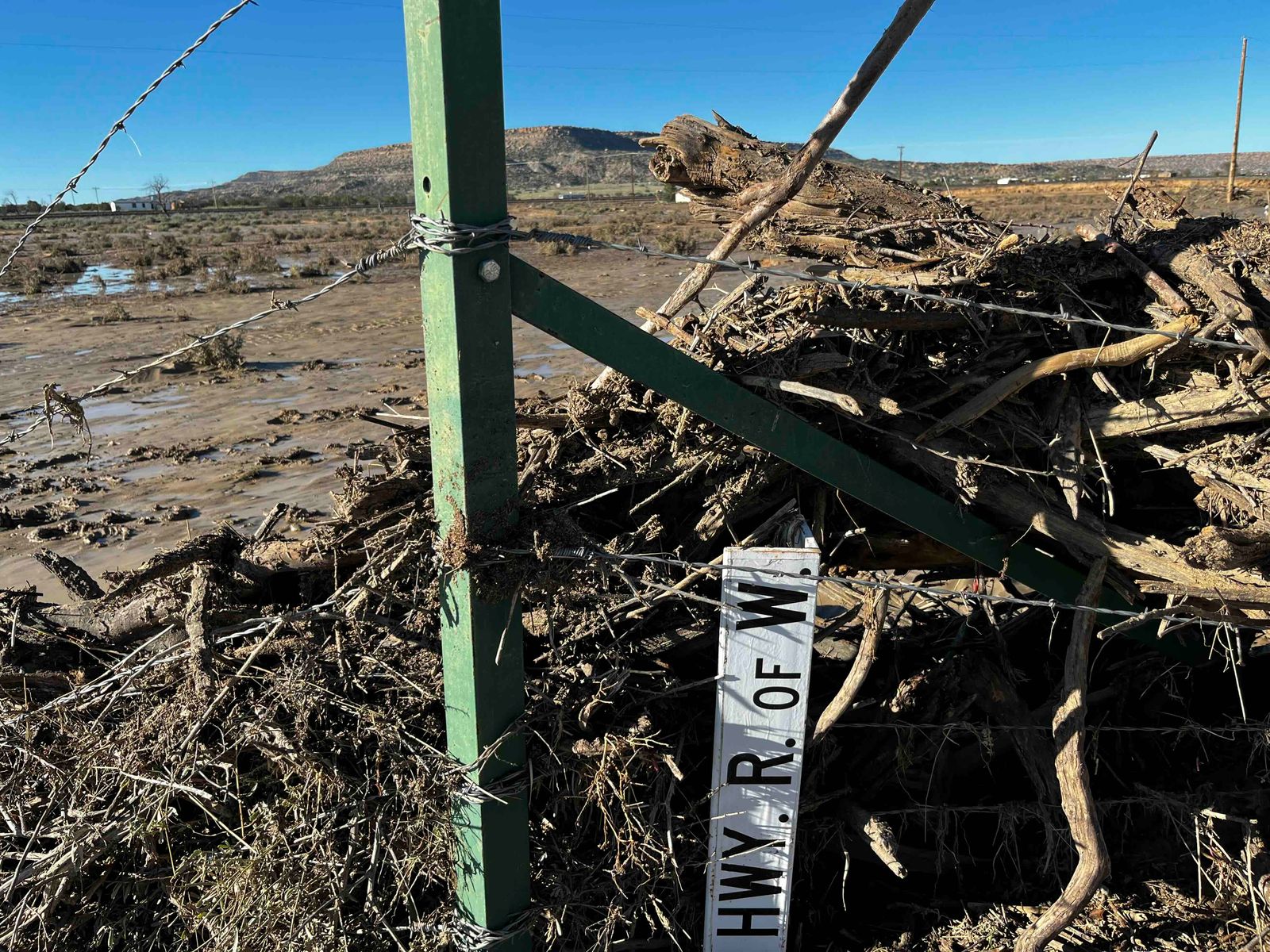 Debris moved from floods in Laguna Pueblo includes a highway sign, Tuesday, Oct. 27, 2026.