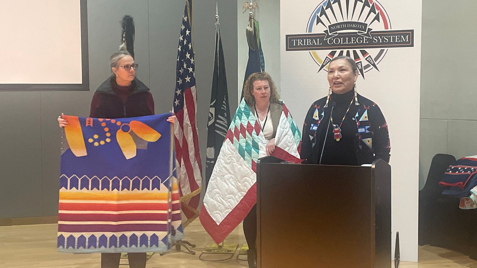 During the celebration on Dec. 5, Sheridan McNeil, director of Tribal Partnerships for the North Dakota Established Program to Stimulate Competitive Research, and Heidi Grunwald, associate vice president for research and faculty development at North Dakota State University, presented a blanket to the board of directors of the Tribal College System in North Dakota in recognition of their 30 years of dedication and service. Photo credit Adrianna Adame