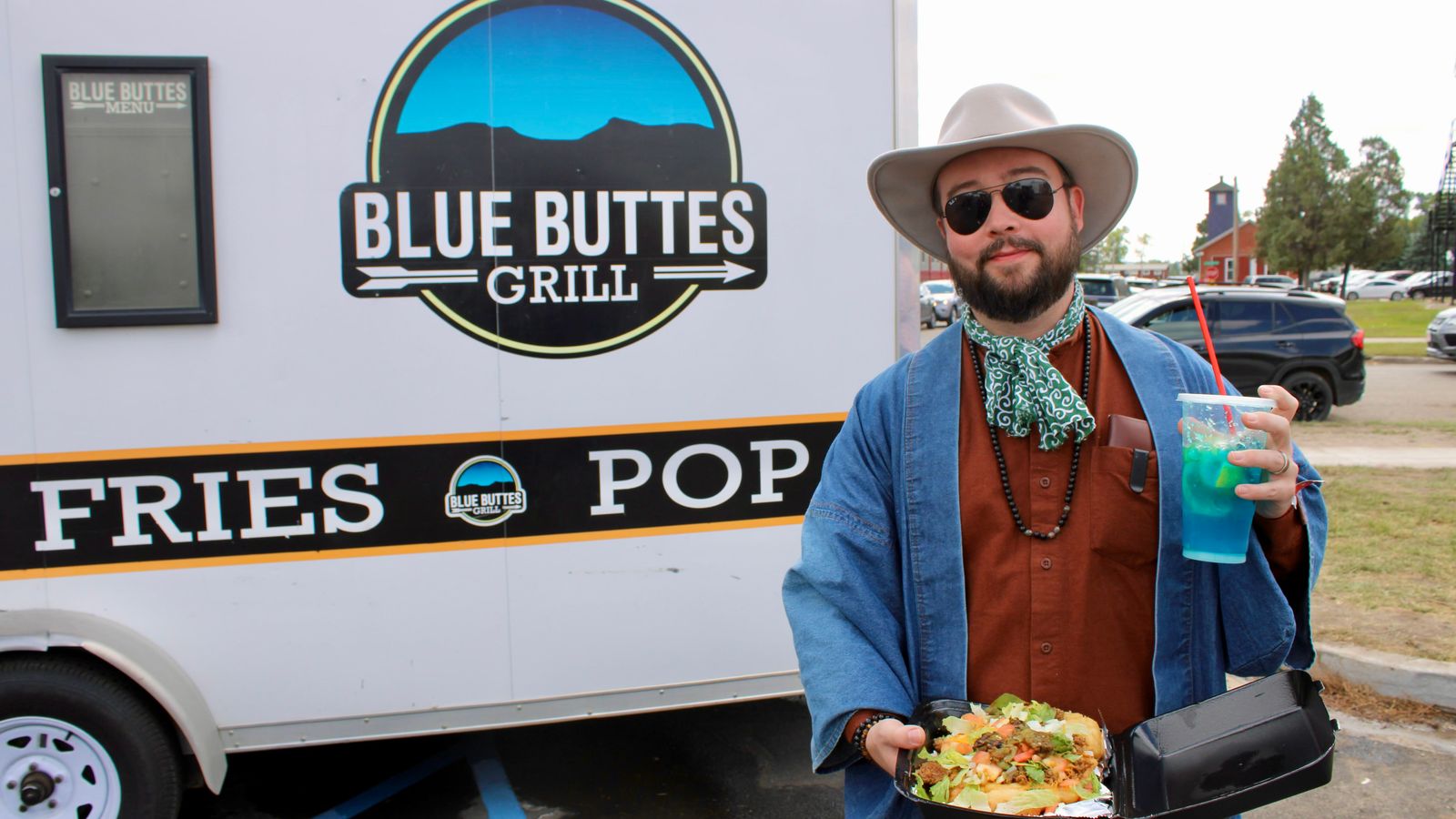 Powwow attendee Rob Buscher stands with an Indian taco from Blue Buttes Grill and a blue “rez” berry lemonade from Rez Famous Lemonades, Bismarck, North Dakota, Saturday, Sept. 6, 2025. (Buffalo’s Fire Photo/Gabrielle Nelson)