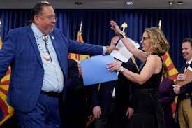 Gila River Indian Community Gov. Stephen Roe Lewis, left, hugs U.S. Sen. Kyrsten Sinema, I-Ariz., at the Capitol, Thursday, April 6, 2023, in Phoenix. Lewis and Sinema were discussing newly announced water conservation funding for Gila River Indian Community and water users across the Colorado River Basin aimed to protect the stability and sustainability of the Colorado River System. (AP Photo/Matt York)