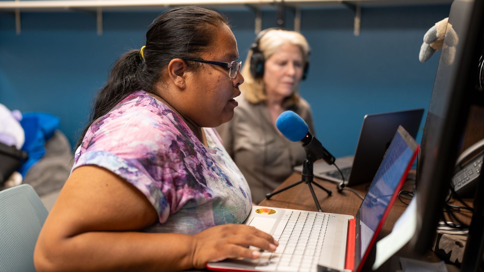 TR Mitchell records a voiceover for an audio story during an All Our Kin class. Mary Ann McNair, director of StoryCenter, a company that helps facilitate storytelling projects, helps Mitchell with the recording.