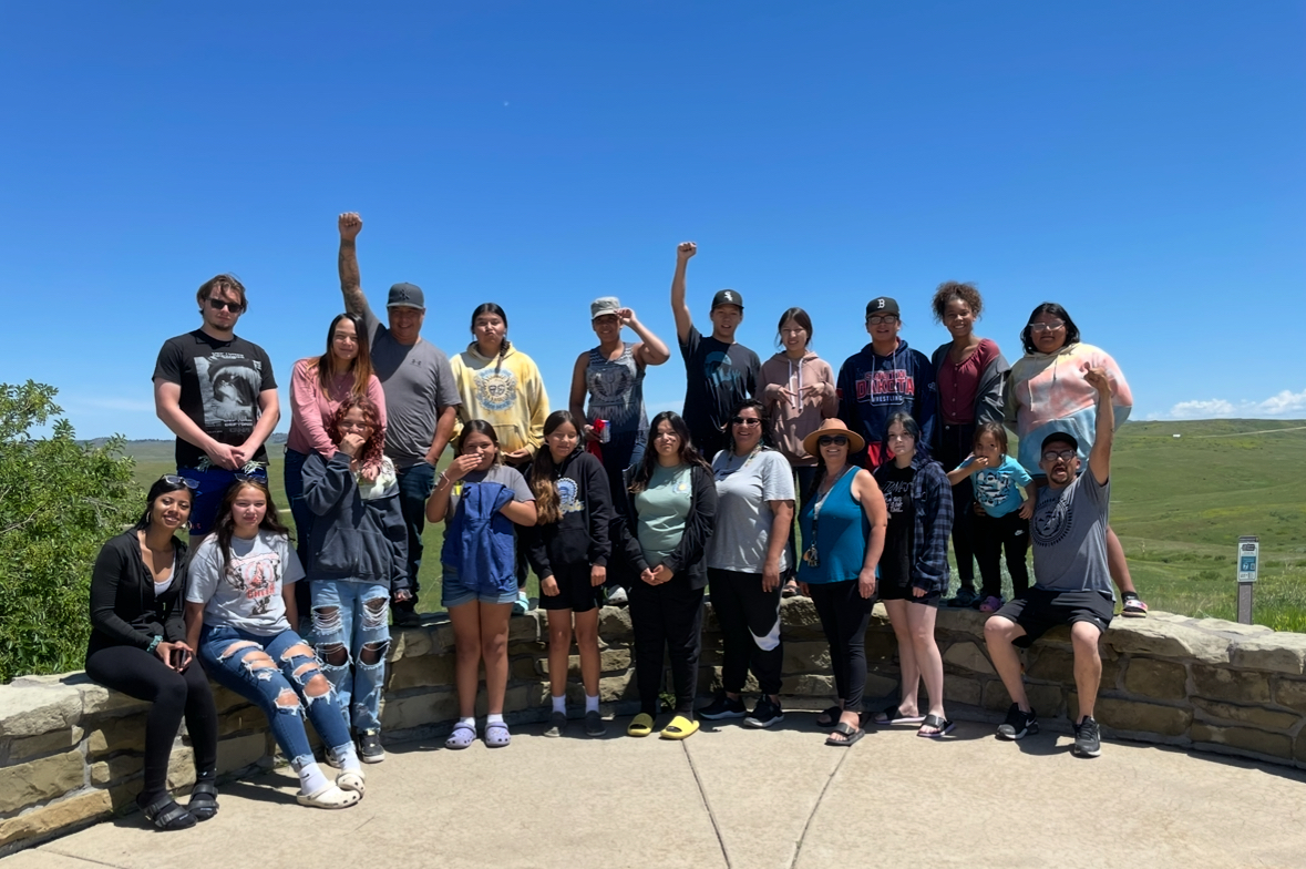 The Defenders of the Water students stand with their instructors, some raising their fists as a symbol of Native solidarity, Little Bighorn Battlefield National Monument, Montana, June 2023.