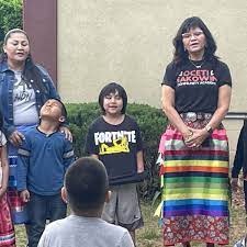Head of school Mary Bowman, at right, leads the students at the Oceti Sakowin Community Academy in the “Four Directions” song, which they sing in a circle each morning prior to classes in Rapid City, S.D. Bowman also reminds children each day to treat themselves and one another with kindness and respect. (Photo: Bart Pfankuch / South Dakota News Watch)
