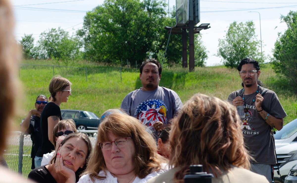Lloyd Big Crow (middle), Lakota and the founder of Oyáte kiŋ čhaŋtéwaštepi watches on as the community meets for a discussion regarding the weekly meals provided to the homeless community. Big Crow has organized the Friday meals since 2018. Photo by Amelia Schafer
