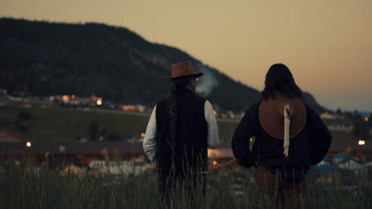 Julian Brave NoiseCat and his father Ed Archie NoiseCat look down at the Williams Lake Stampede from the top of “Indian Hill” on their roadtrip back to St. Joseph’s Mission, where Ed was born. (Credit: Emily Kassie/Sugarcane Film LLC)